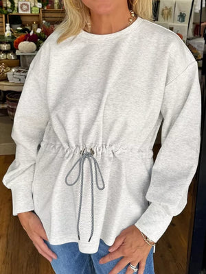 Light gray drawstring waist tunic sweatshirt with crew neck and long sleeves.
