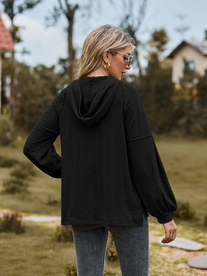 Black textured knit hoodie with balloon sleeves and a hood