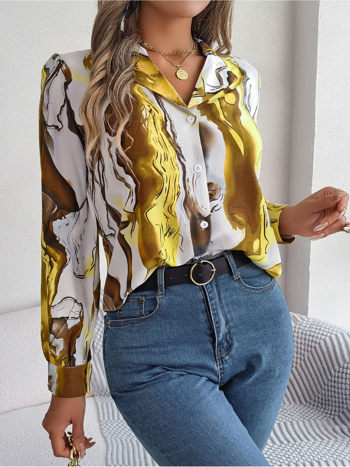Women's abstract swirl print silk blouse in yellow and white with button front and collared neckline.