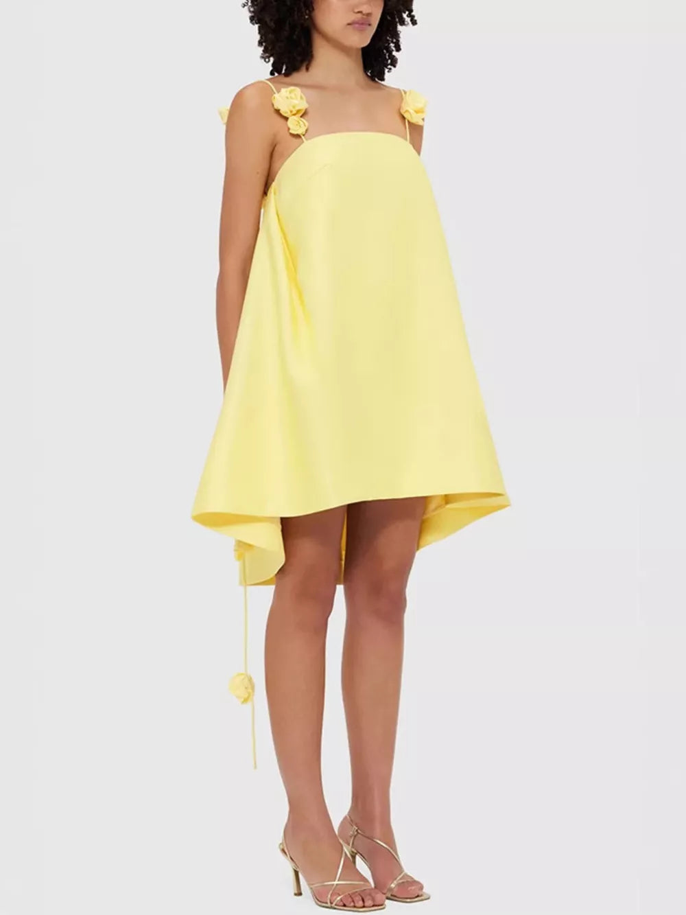 Yellow A-line mini dress with floral applique straps and hem detail.