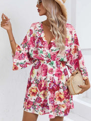 Floral mini dress with V-neck, flutter sleeves, and tiered ruffle hem.