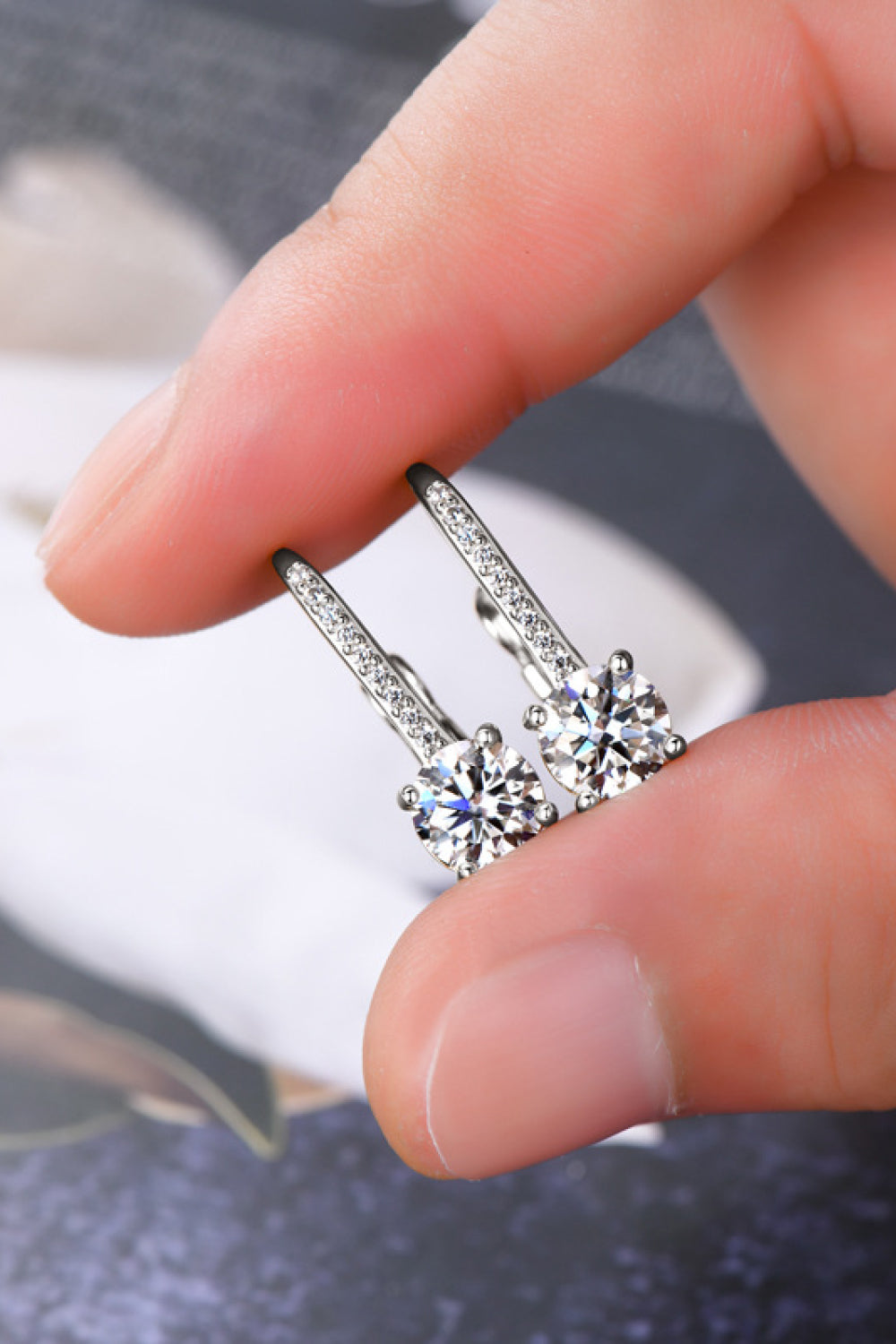 Silver leverback earrings with pavé-set moissanite and a round-cut center stone.