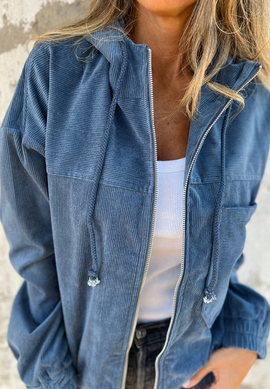 Dusty blue corduroy bomber hoodie with relaxed fit, zip front, and drawstring hood.