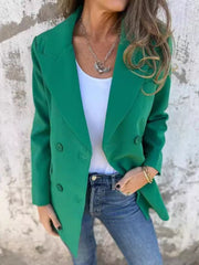 Green double-breasted blazer with sculpted lapels and button detail, worn with jeans.