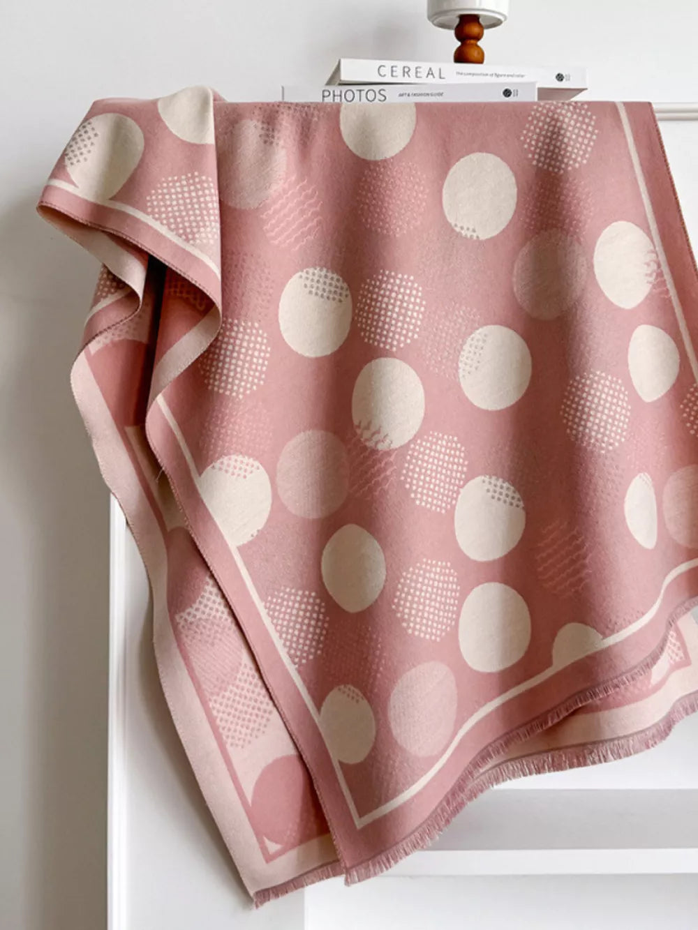 Dusty pink textured scarf with large cream polka dots and a fringed hem.