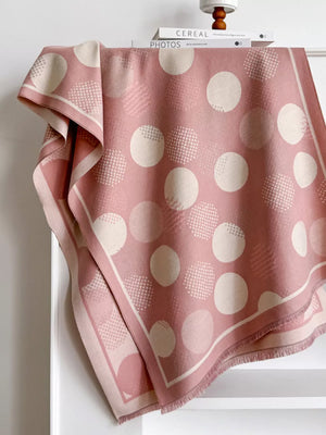 Dusty pink textured scarf with large cream polka dots and a fringed hem.