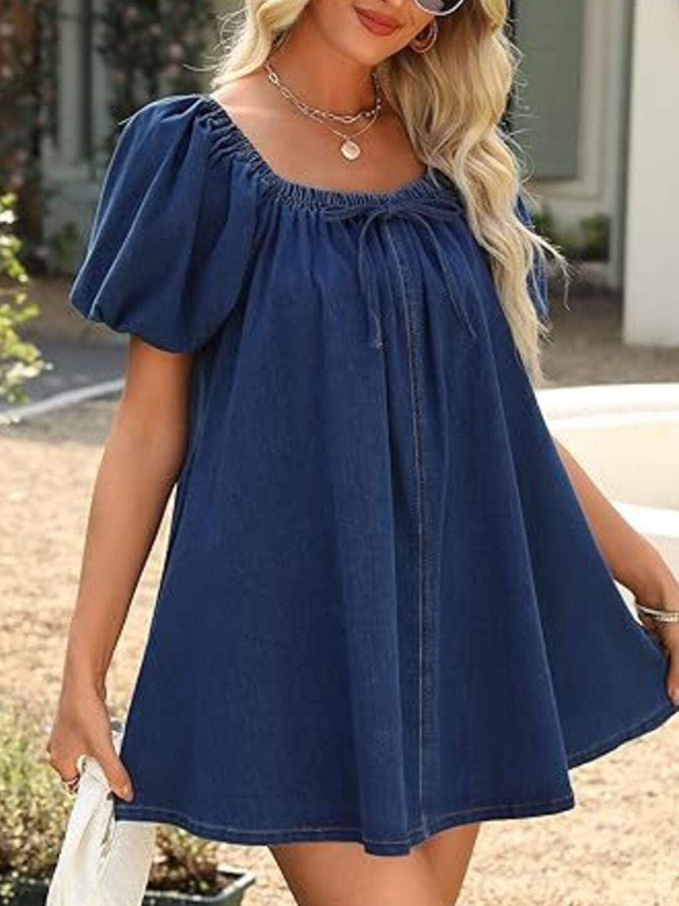 Dark blue denim off-shoulder mini dress with puff sleeves and tie-front neckline.