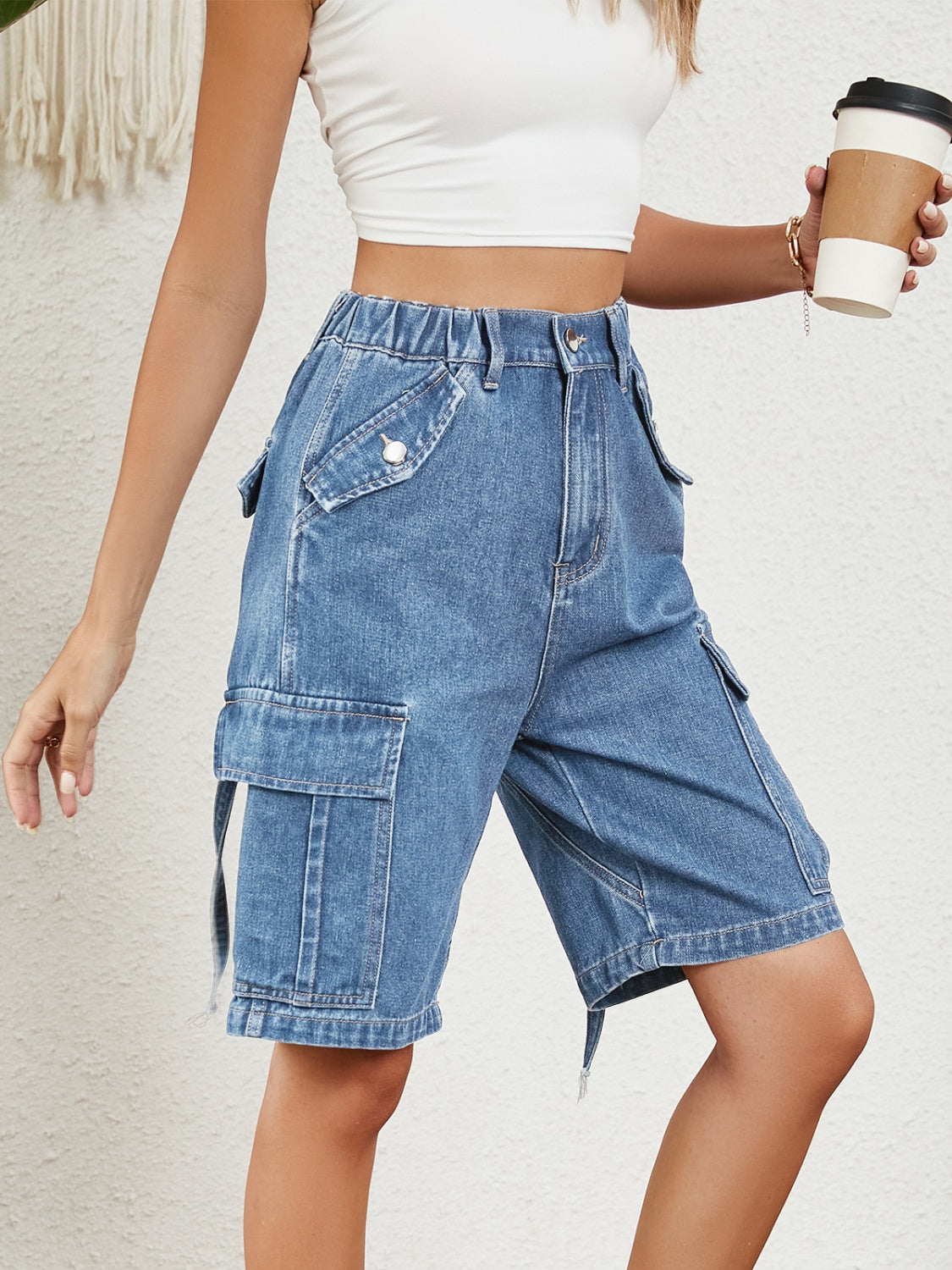Denim Bermuda shorts in medium blue wash with cargo pockets and elastic waistband.