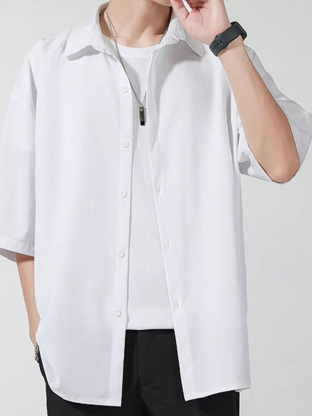 Men's white oversized short sleeve button-up shirt with a white t-shirt underneath.