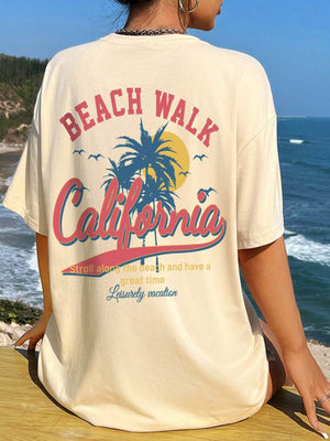 Tan oversized graphic tee with California beach scene and text, crew neck, short sleeves.