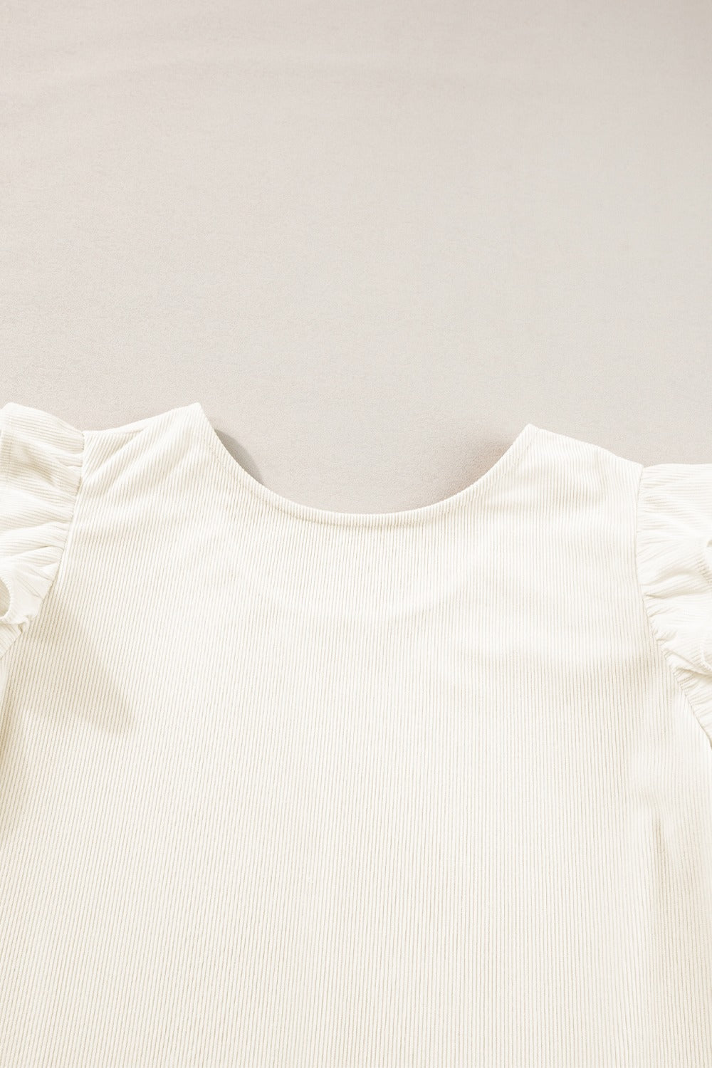 Eggshell textured blouse with ruffle sleeves and a scoop neck.
