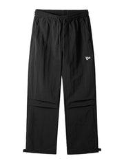 Black utility joggers with drawstring waist, cargo pockets, and adjustable ankle cuffs.