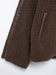 Dark brown teddy fleece zip-up jacket with contrast faux leather piping and pocket trim.
