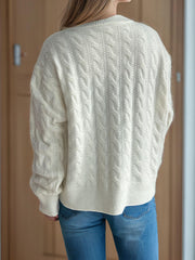 White cable knit cardigan with puff sleeves and ribbed trim.