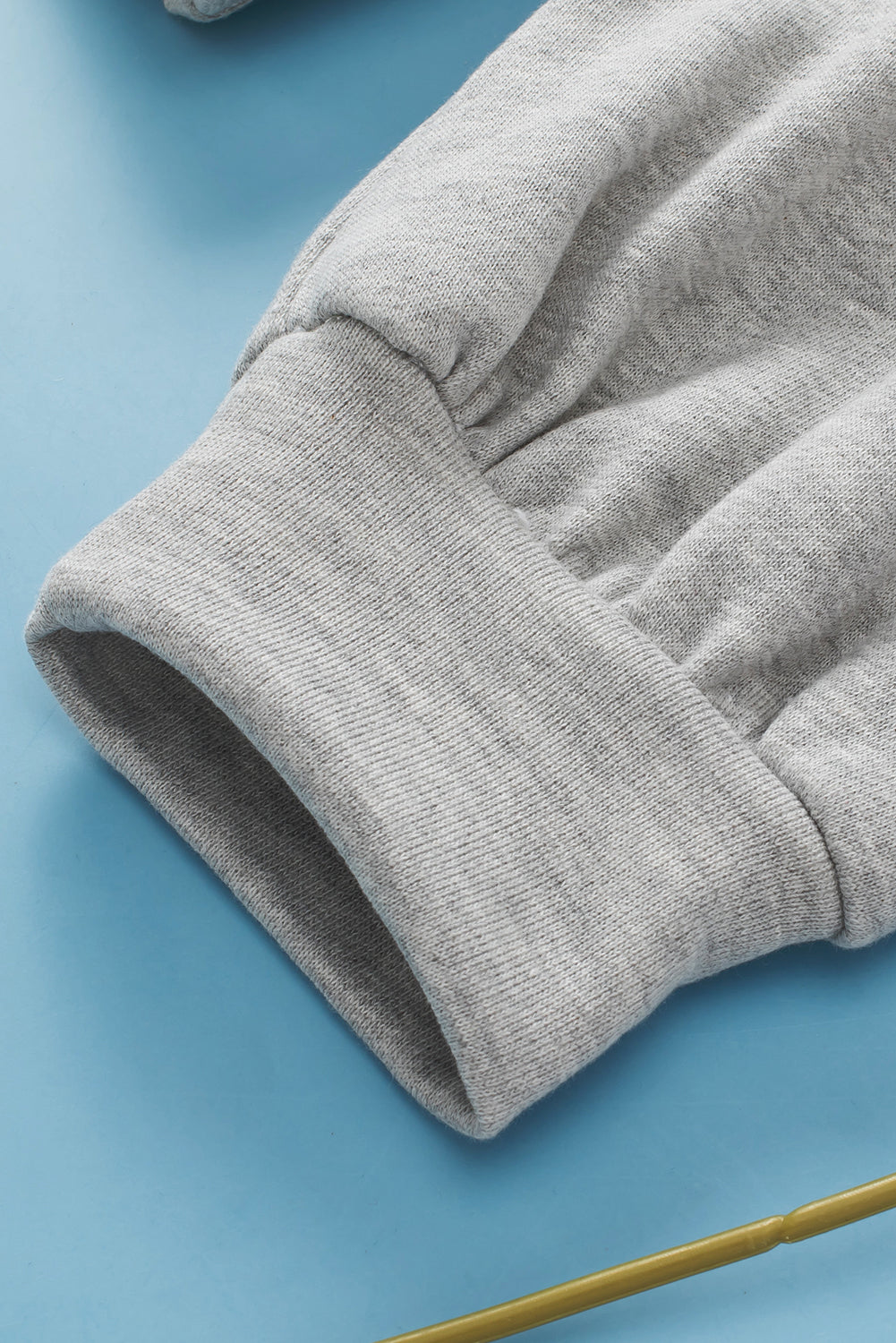 Light gray sweatshirt cuff detail, casual knit fabric, relaxed fit