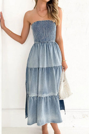 Light blue smocked denim strapless maxi dress with tiered skirt and side slits.