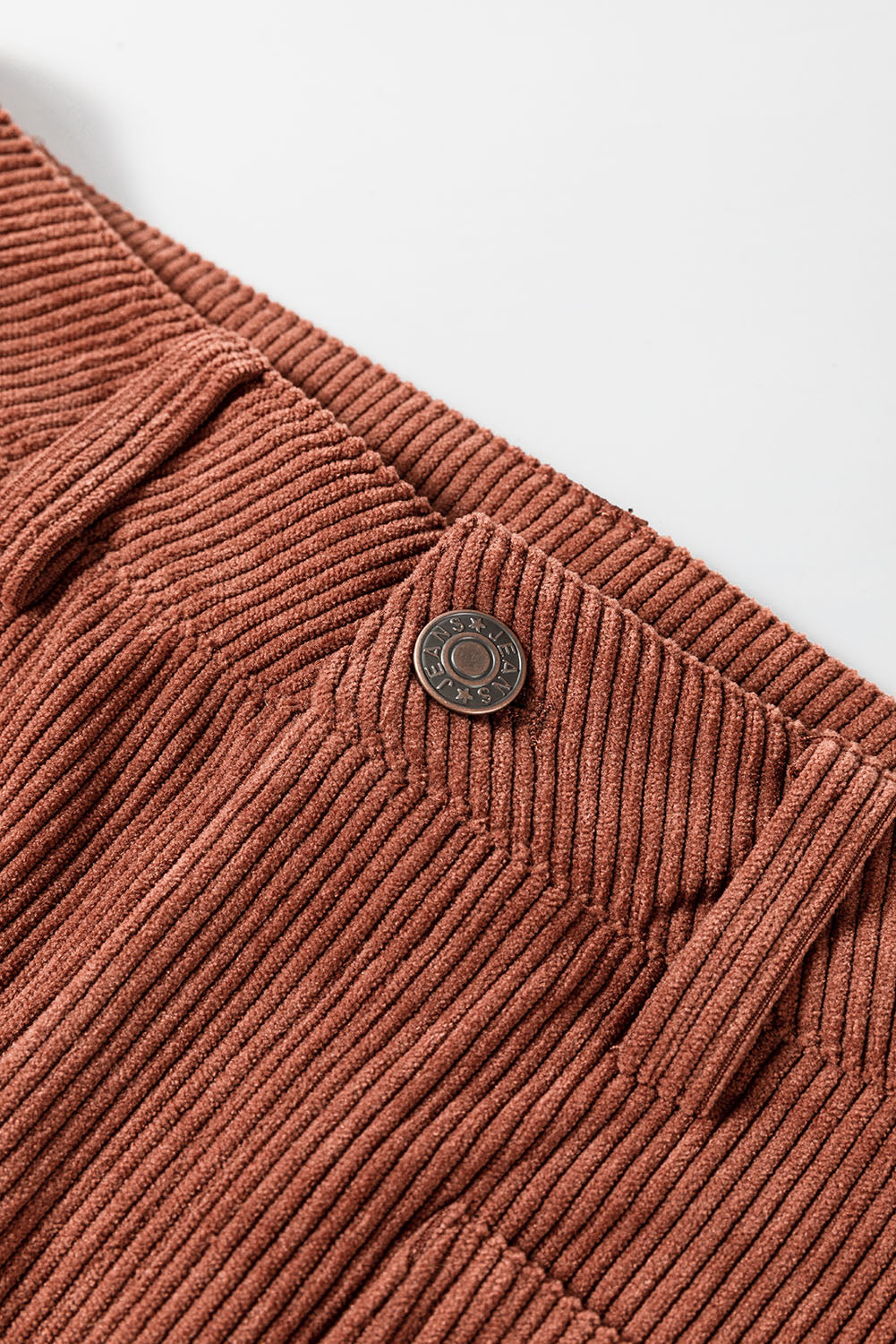 Brown corduroy flared leg trousers with a button closure detail.
