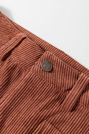 Brown corduroy flared leg trousers with a button closure detail.
