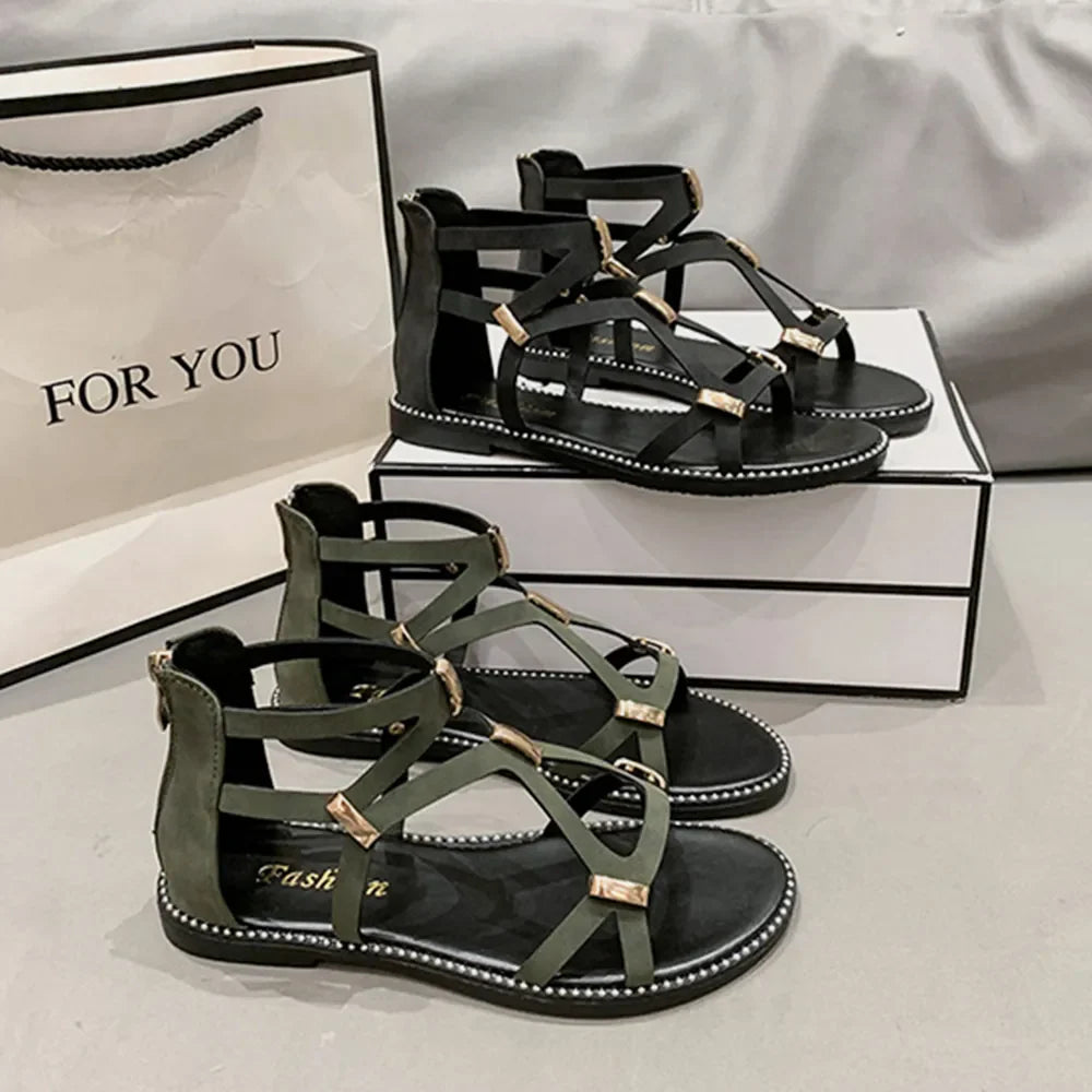 Gladiator zip-back sandals in army green and black with gold accents and strappy design.