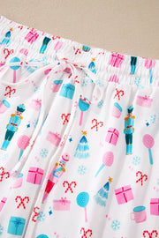 White pajama pants with a festive nutcracker, candy cane, and gift print.