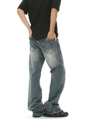 Men's loose fit vintage wash blue denim jeans with frayed hems.