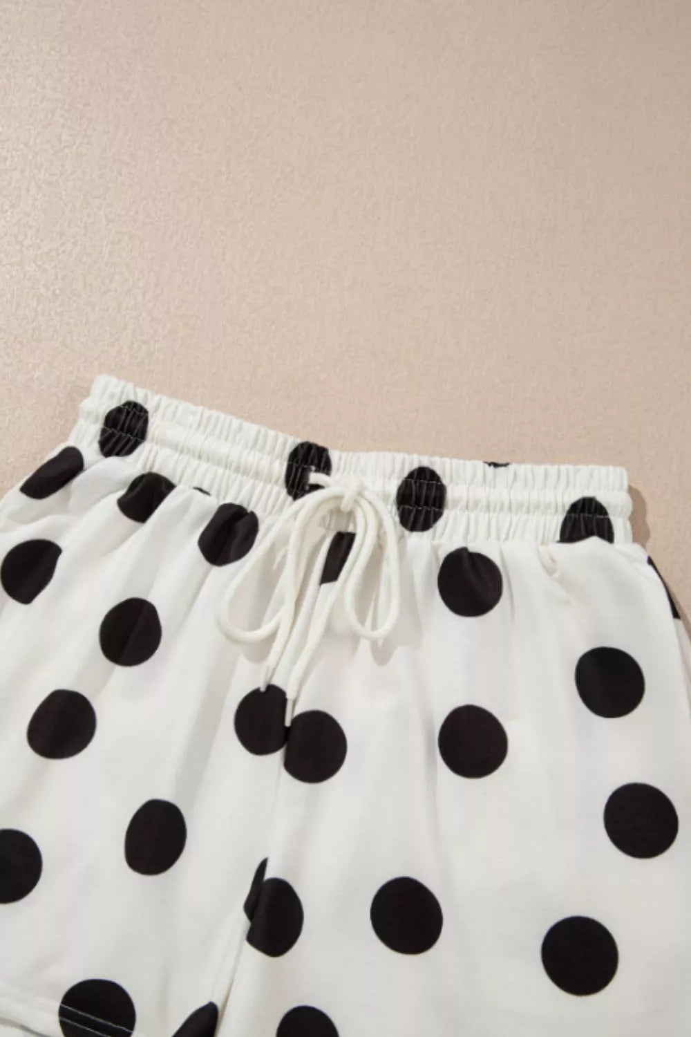 White polka dot lounge shorts with drawstring waist and elastic band.