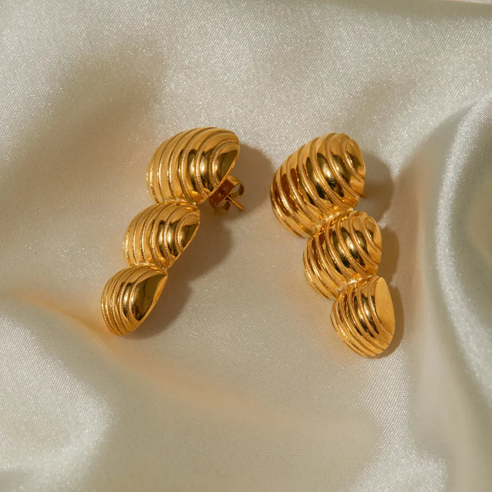 Gold drop earrings with sculptural spiral design, 18K gold-plated.