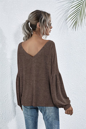 Mocha knit top with blouson sleeves and deep V-neck, styled with jeans.