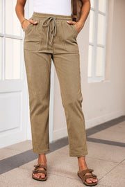 Khaki corduroy drawstring trousers with slant pockets and a relaxed fit.