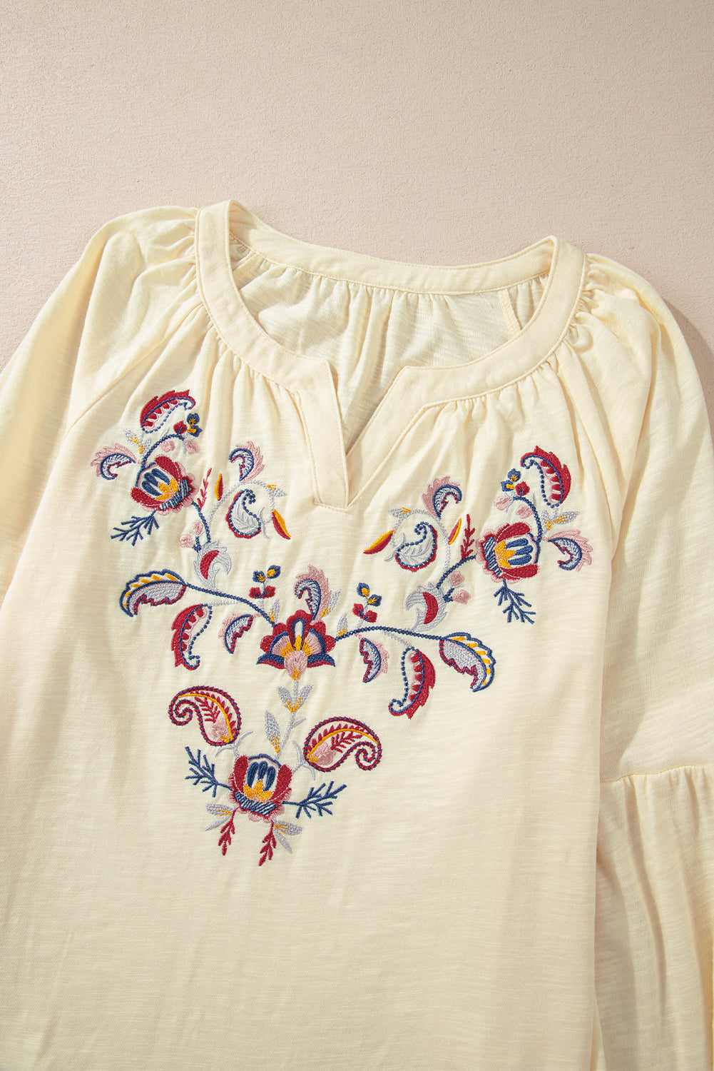 Pastel yellow embroidered blouse with V-neck and poet sleeves.