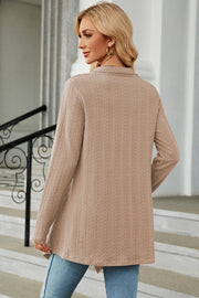 Tan textured knit cardigan with asymmetrical hem and long sleeves.