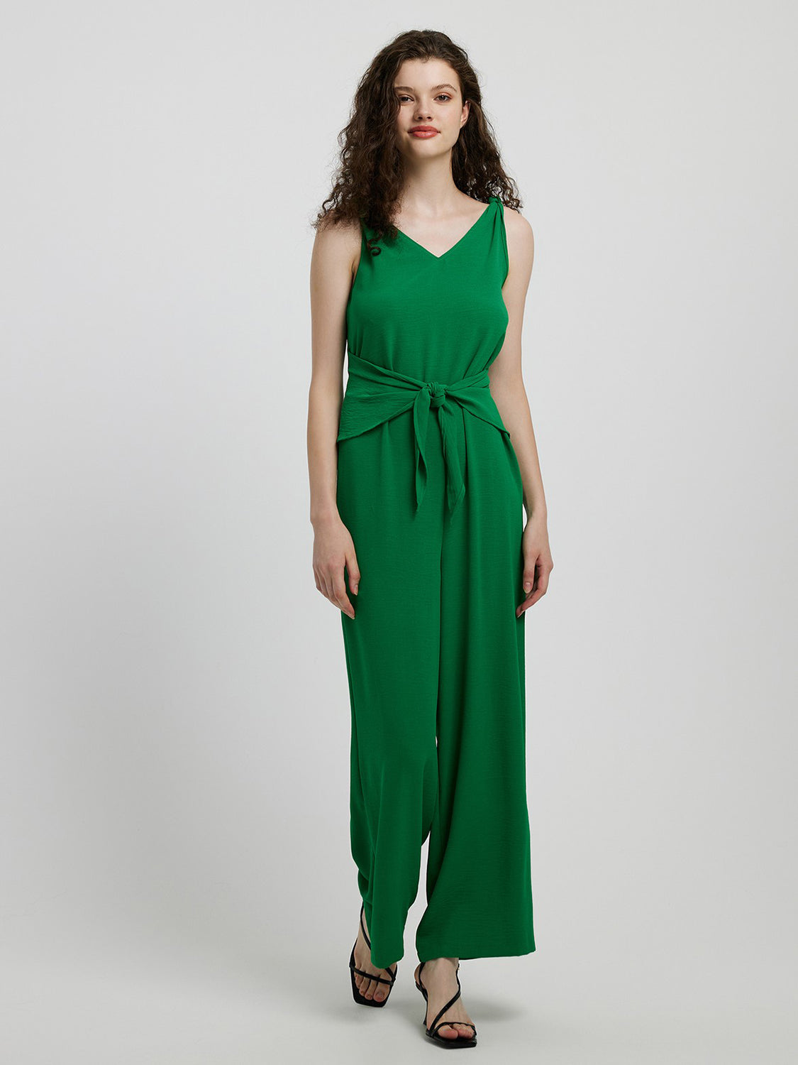 Emerald tie-waist wide leg jumpsuit in mid green with a V-neck and sleeveless design.