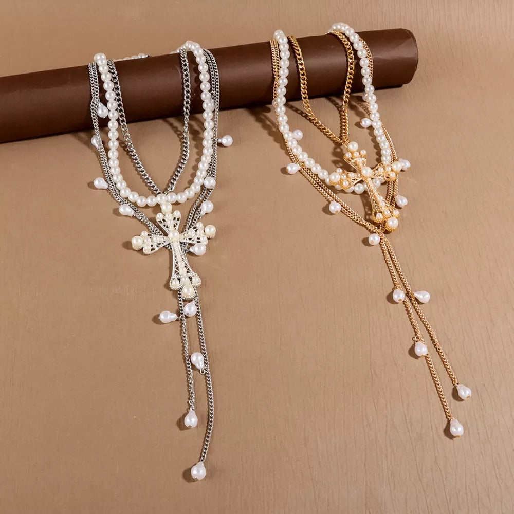 Lustrous pearl cross pendant necklaces in silver and gold with dangling pearls.