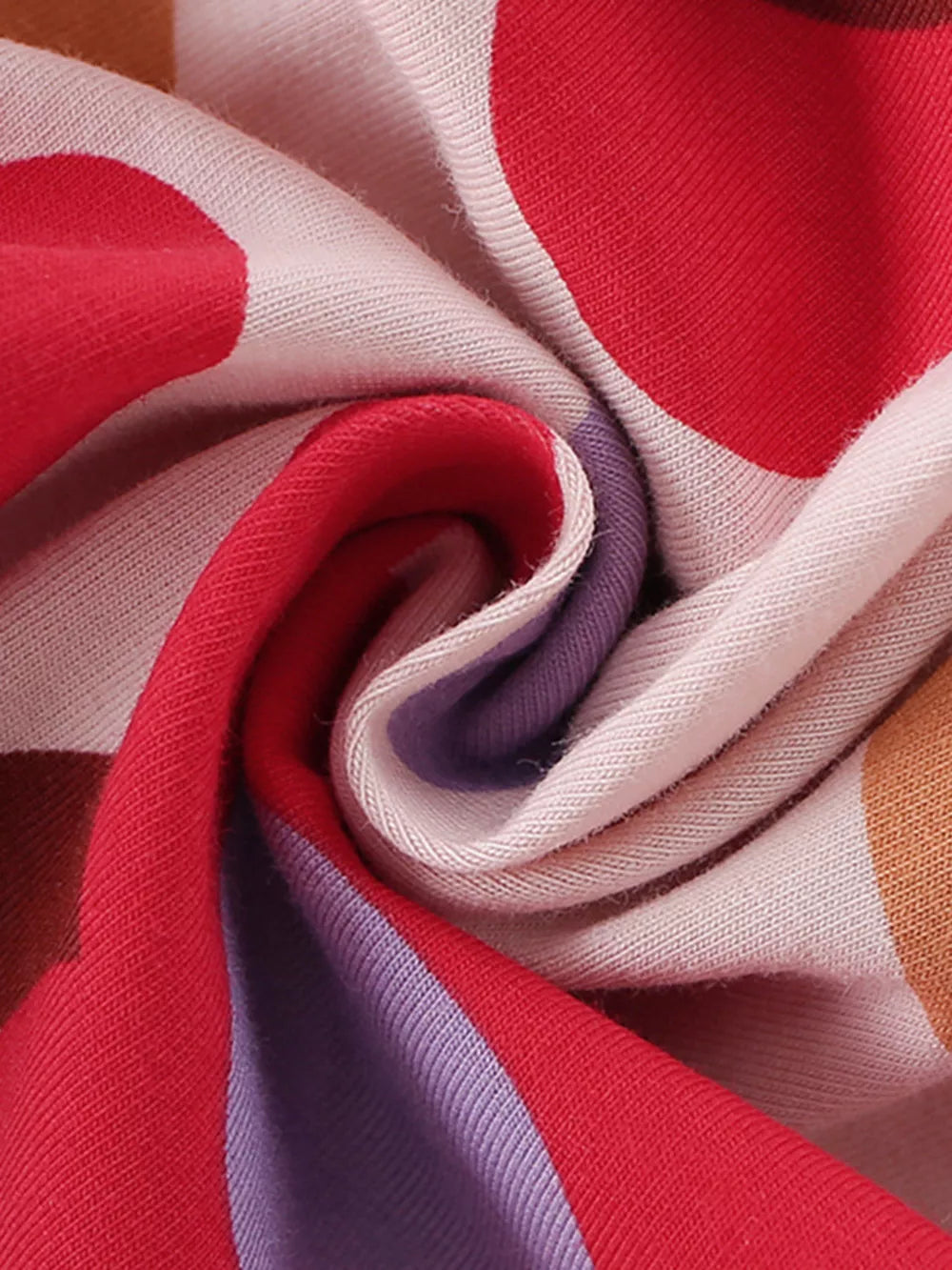 Toddler dress fabric detail with red, purple, and tan polka dots and stripes on cotton.