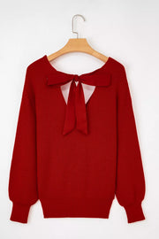 Red knit sweater with backless detail and large satin bow.