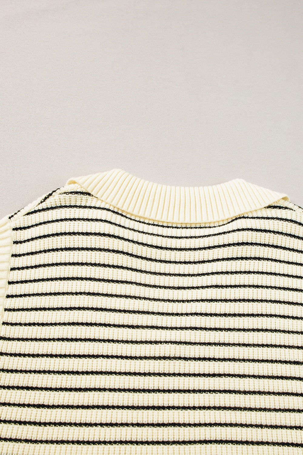 Ivory and black striped knit polo vest with ribbed collar detail.