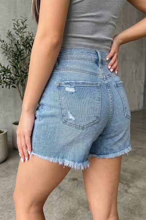 Light wash denim shorts with distressed details and a raw hem.