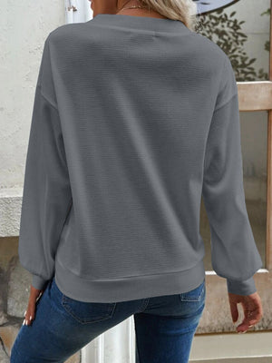 Dark gray waffle knit button-down cardigan with long sleeves and crew neck.