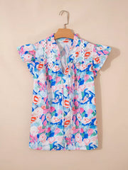 Vibrant floral tie neck cotton blouse with ruffle sleeves and eyelet trim.