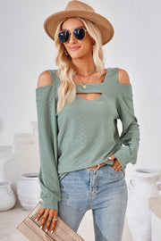 Light green textured blouse with cutout shoulders and neckline detail.