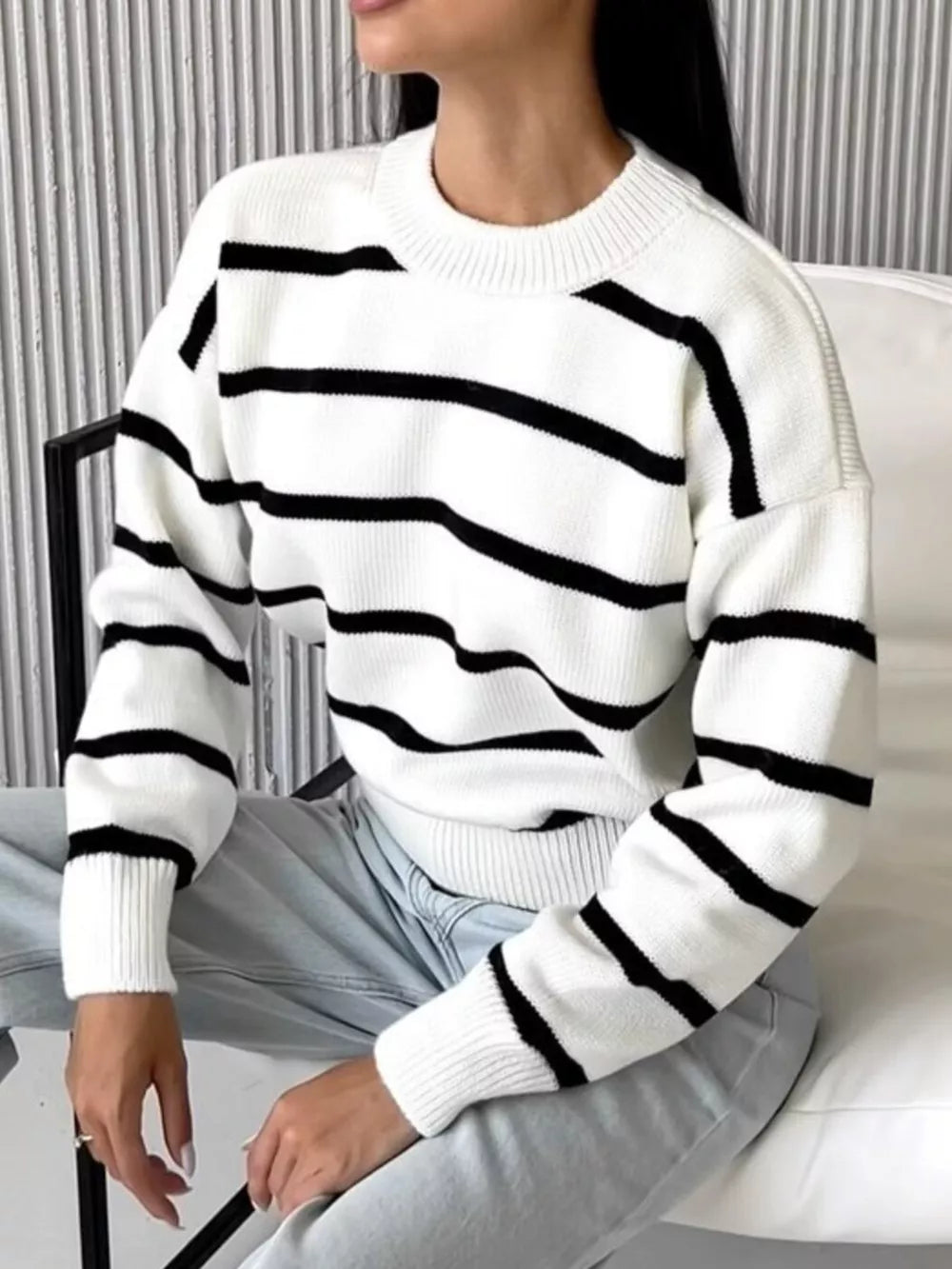 Classic white knit sweater with black stripes and round neck.