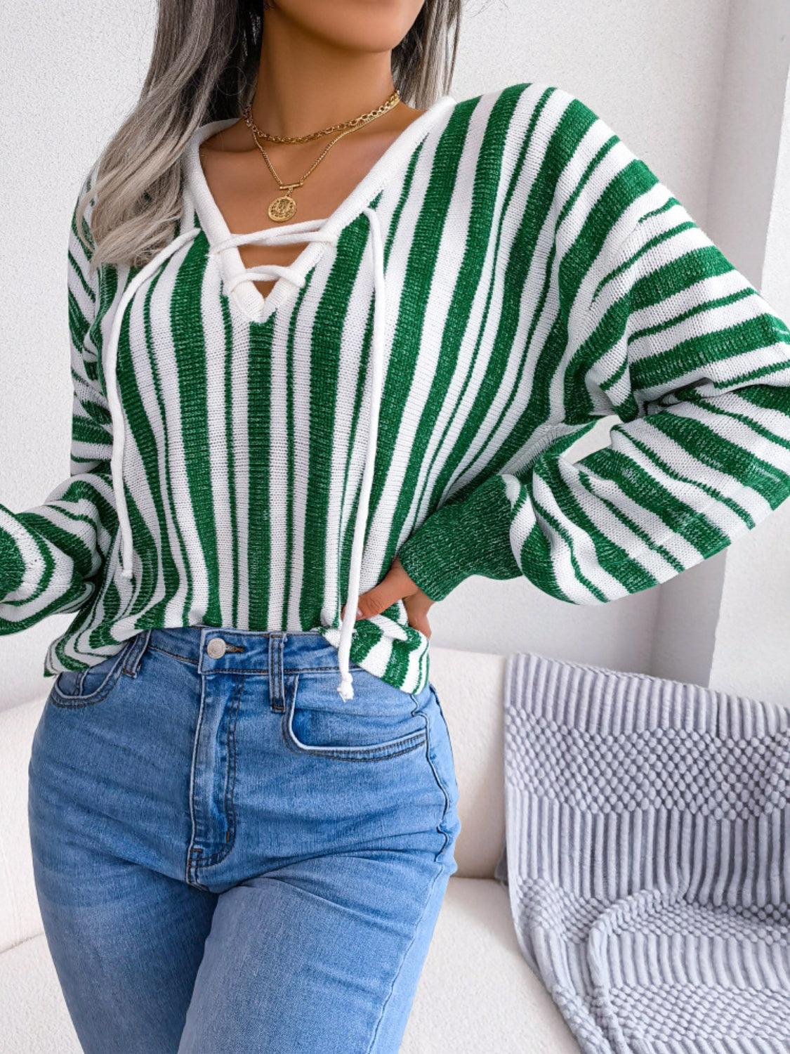 Green and white striped knit cropped pullover sweater with lace-up neckline.