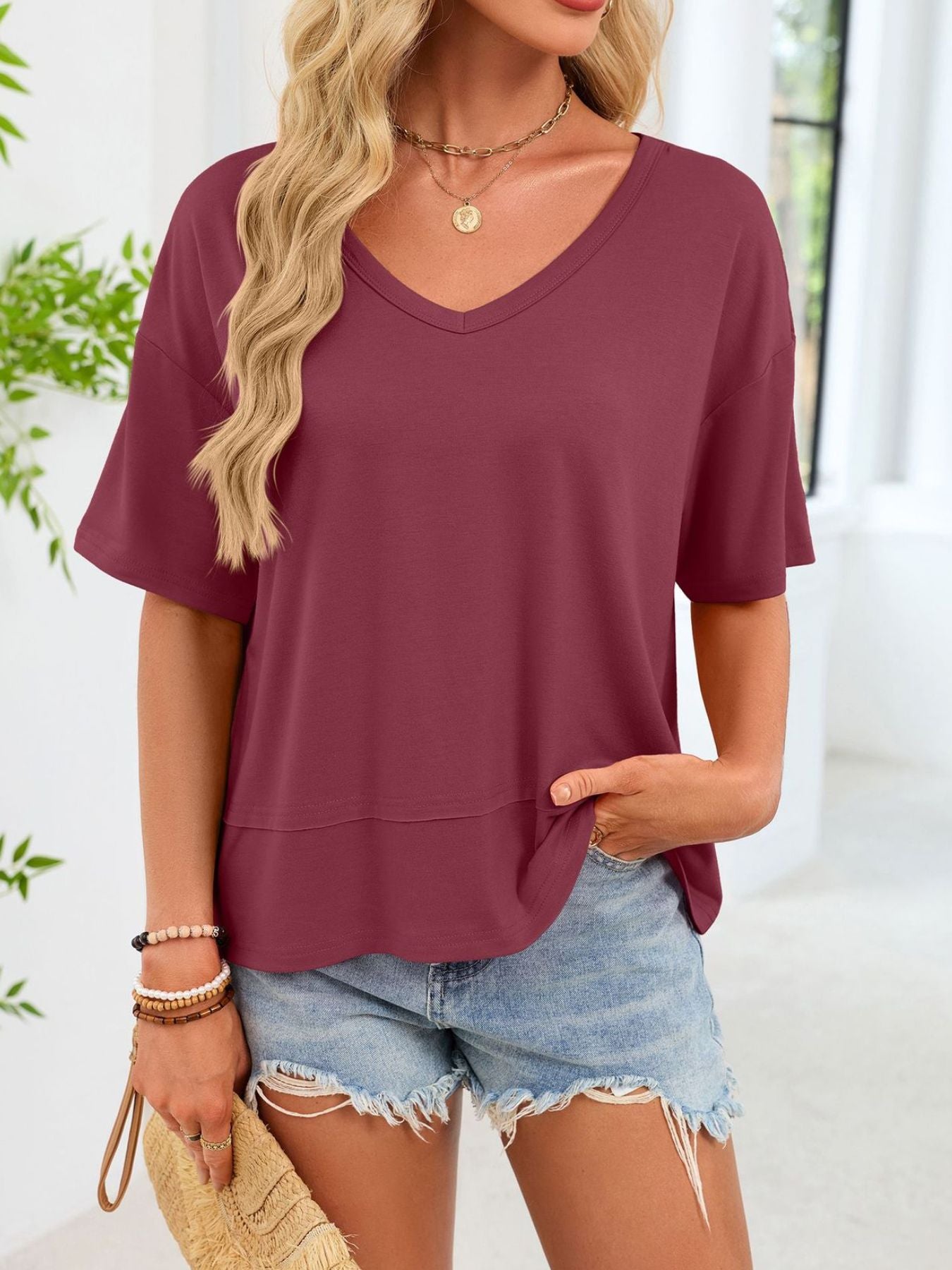 Relaxed fit V-neck t-shirt in wine red with short sleeves and a layered hem.