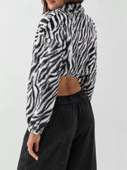 Plush cropped jacket in black and white zebra print with drawstring closure.