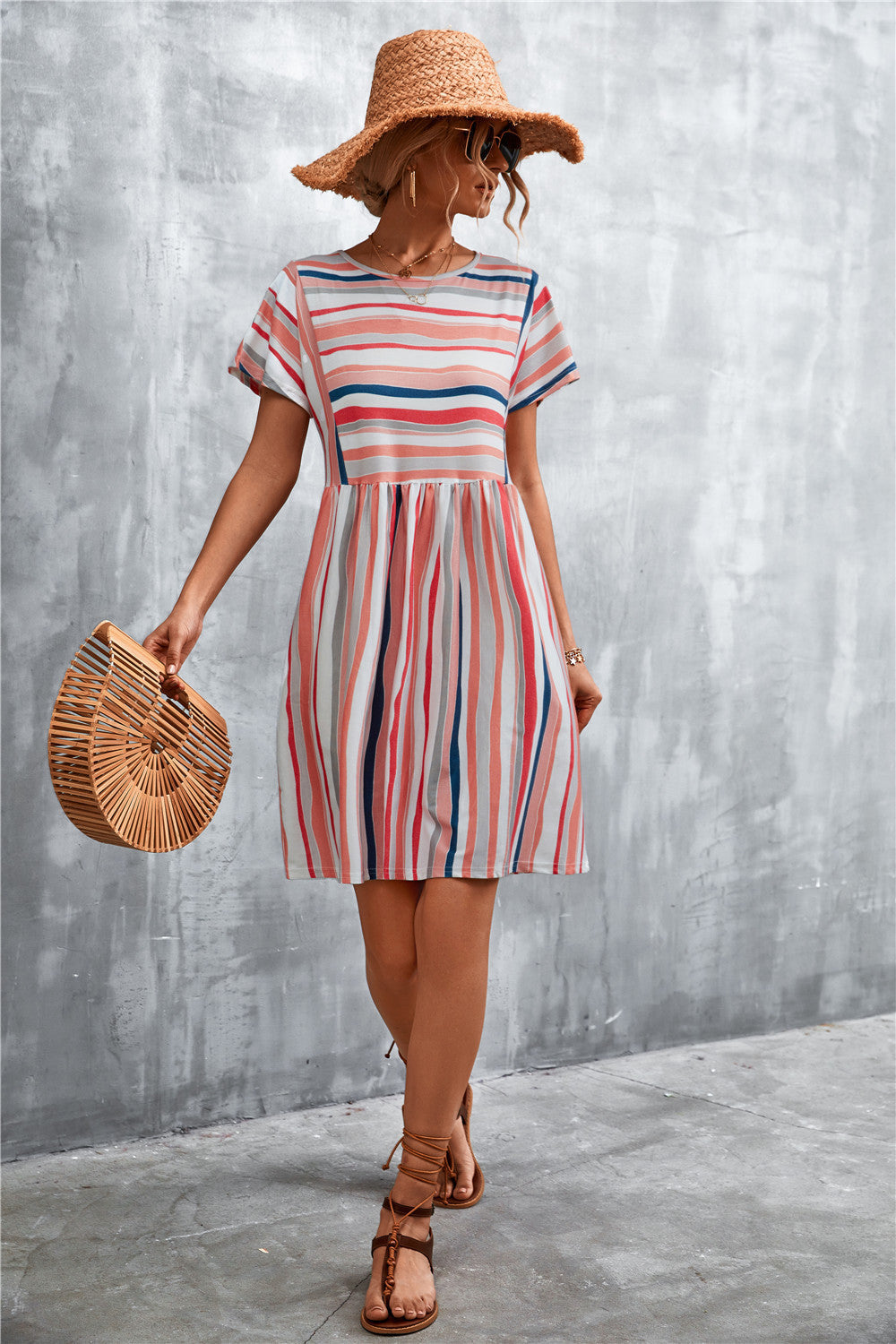 Striped trapeze dress with yoke seam and short sleeves in coral and white stripes.