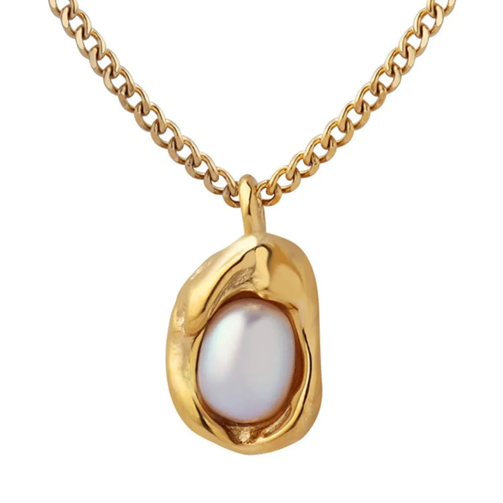 Gold necklace with a unique abstract charm holding a lustrous pearl.