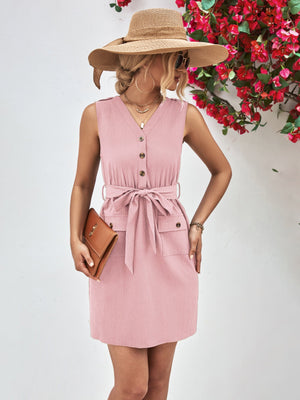 Button-down tie-waist sleeveless shirtdress in blush pink with buttoned pockets and a belted waist.