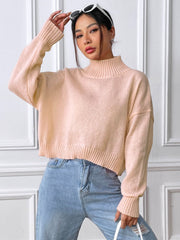 Cropped ribbed turtleneck sweater in blush pink with long sleeves and a relaxed fit.