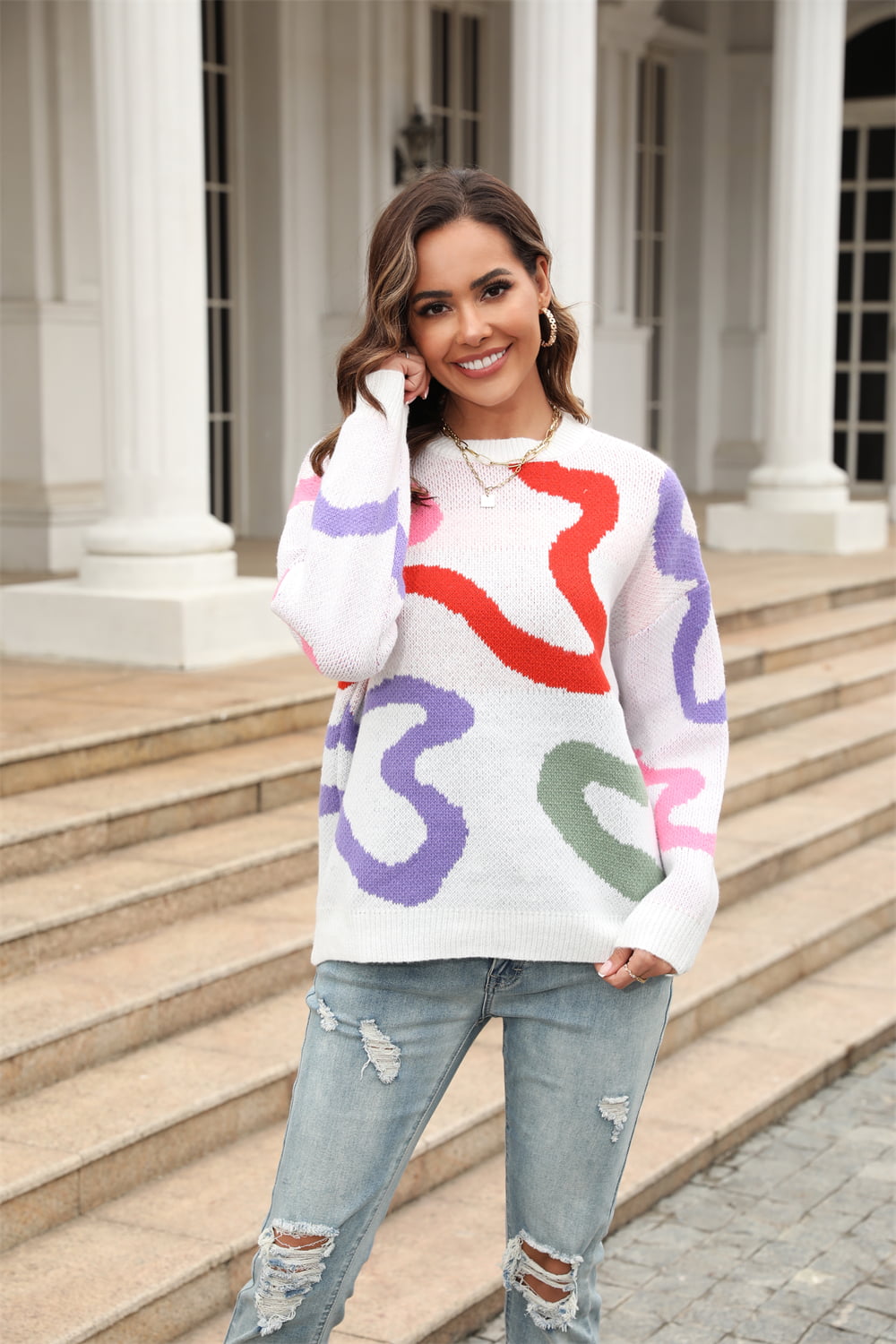 White crewneck sweater with abstract swirl pattern in red, purple, pink, and green.