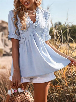 Light blue textured peplum blouse with ruffle trim and short sleeves.